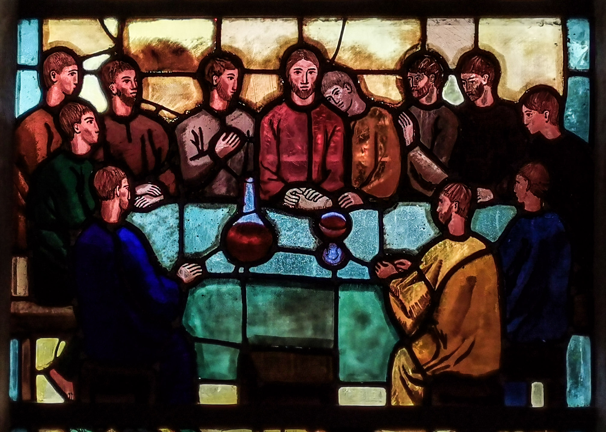 billede af glasmaleri der forestiller nadveren. disciplene omkring et bord.